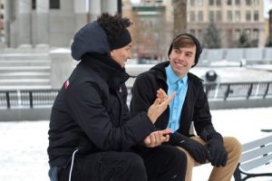 two people seated on a bench having a conversation